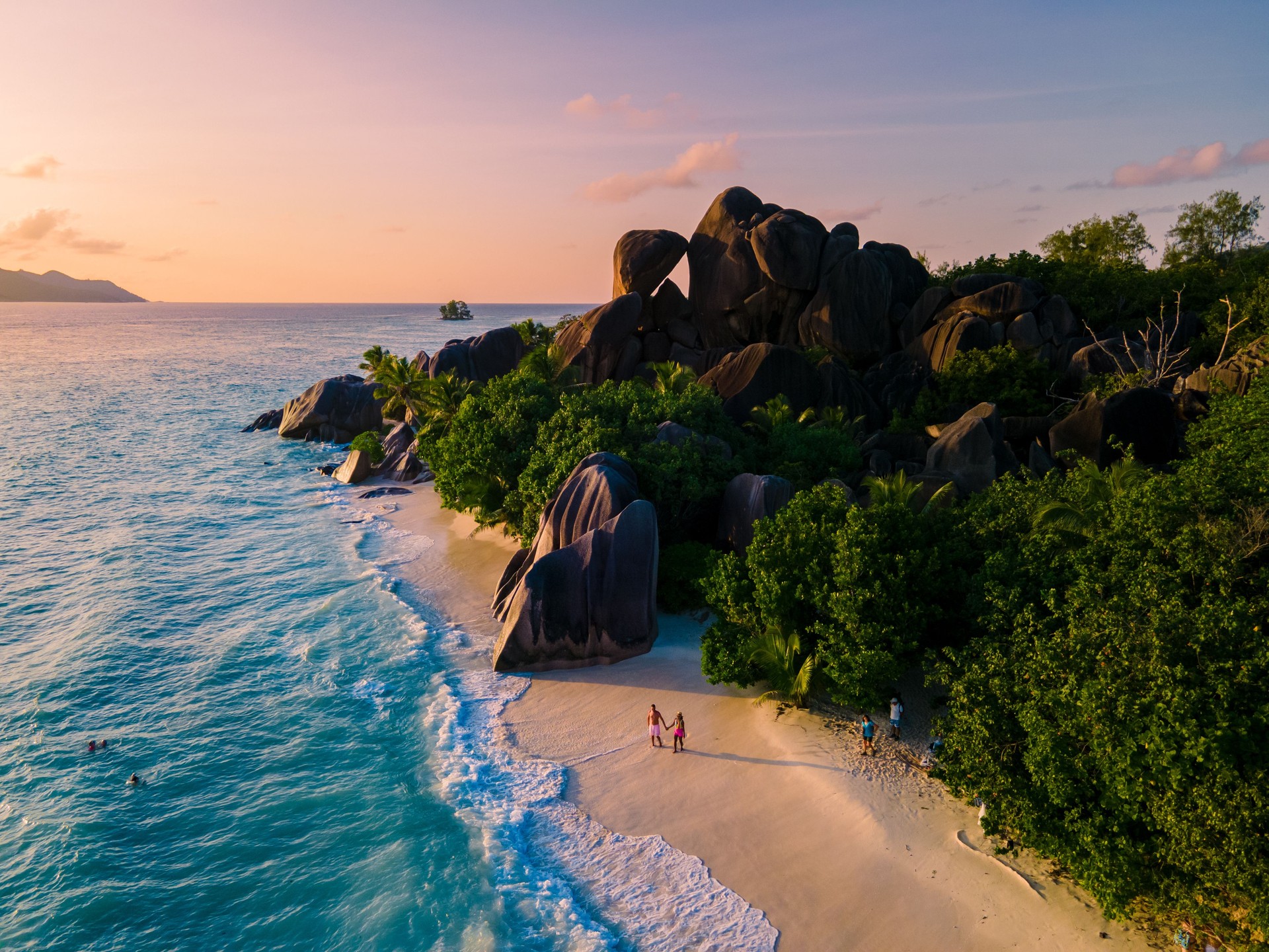 Anse Source d'Argent, La Digue Seychelles, young couple men and woman on a tropical beach during a luxury vacation in the Seychelles. Tropical beach Anse Source d'Argent, La Digue Seychelles